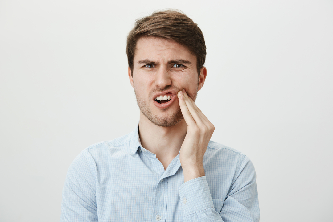 Persona che prova dolore provocato dal dente del giudizio